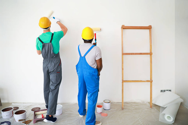 Decoradores masculinos pintando pared ligera
 - Foto, imagen