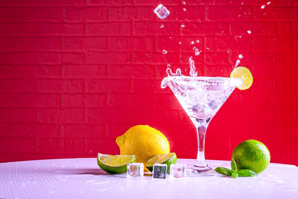 Vermouth in a martini glass and a slice of lime on a red background, copy space. - Photo, Image