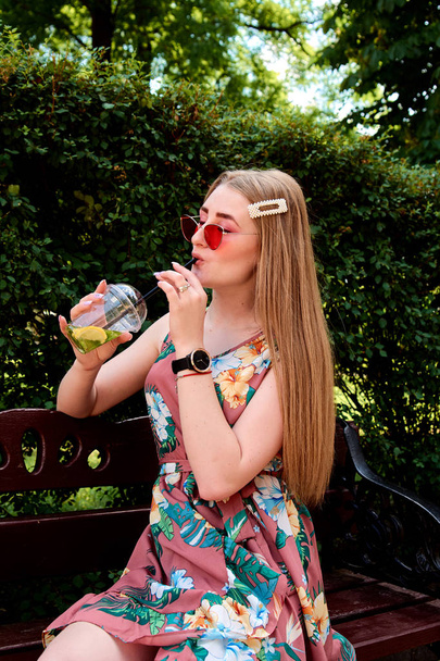 Šťastná radostná mladá žena s barevnými bavlněnými sladkostmi pije čerstvý Mojito koktejl. - Fotografie, Obrázek