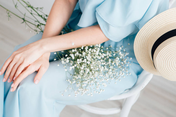 Girl with long hair and hat posing with a bouquet of white flowers - Foto, Imagen