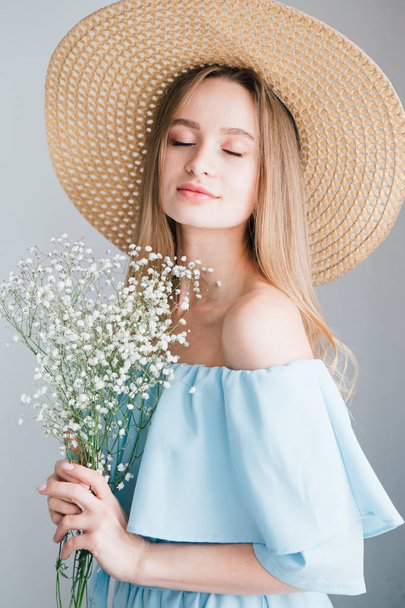Girl with long hair and hat posing with a bouquet of white flowers - Fotografie, Obrázek