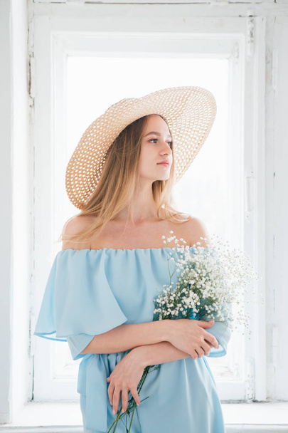 Girl with long hair and hat posing with a bouquet of white flowers - Foto, Imagem