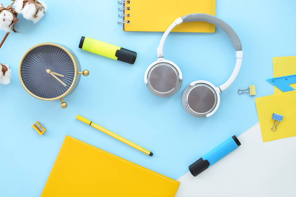 Composition with stationery, alarm clock and headphones on color background - Фото, изображение