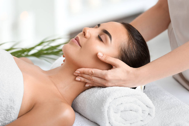 Belle jeune femme recevant un massage dans un salon de spa - Photo, image