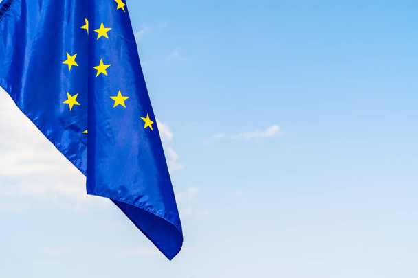European Union flag against blue sky waving - Foto, afbeelding