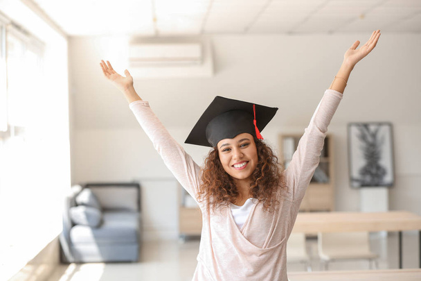 Happy African-American student wearing graduation hat in classroom - Photo, image