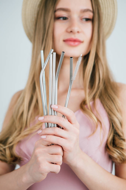 Girl holds in hands reusable metal drinking straws for cocktails - Zdjęcie, obraz