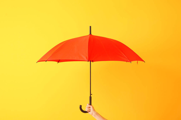 Female hand with stylish umbrella on color background - Фото, зображення