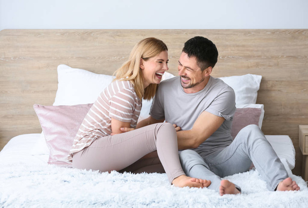 Portrait of happy couple on bed at home - Φωτογραφία, εικόνα