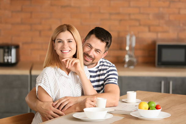 Happy couple having breakfast in kitchen - Fotoğraf, Görsel
