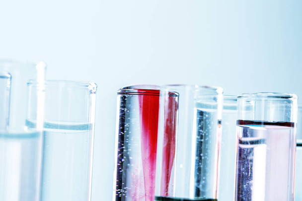 Different laboratory glassware with colored liquids close up - Fotó, kép