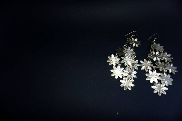 virág alakú fülgyűrű fekete háttér - Fotó, kép