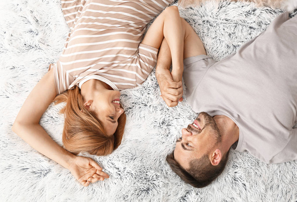 Szczęśliwy para w miłość leżąc na łóżko, widok z góry - Zdjęcie, obraz