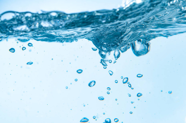 gros plan de bulles dans l'eau bleue bouillante sur fond blanc
 - Photo, image