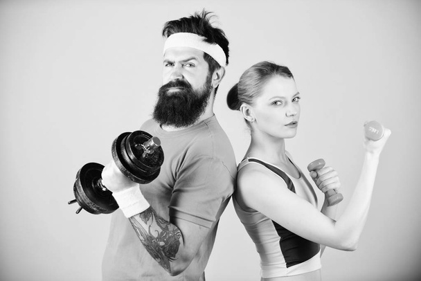 Fitness exercises with dumbbells. Workout with dumbbells. Girl and guy hold dumbbells. Fitness sport exercises. Sporty family. Healthy lifestyle concept. Man and woman exercising with dumbbells - Foto, afbeelding