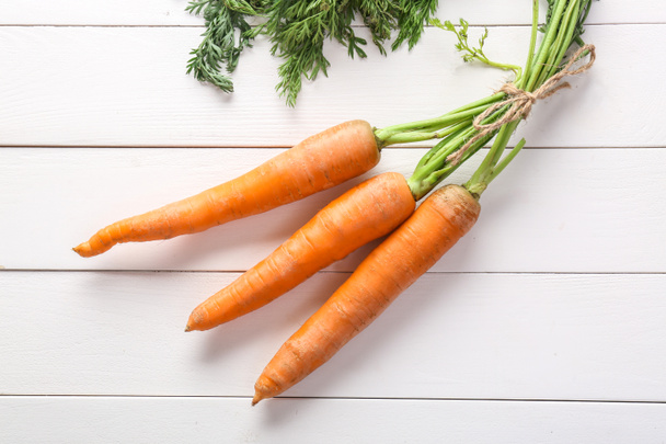 Tasty fresh carrot on white wooden background - Фото, зображення