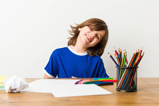 Маленький мальчик рисует и делает домашнюю работу на своем столе больной, страдающий от боли в животе, болезненной концепции болезни
. - Фото, изображение