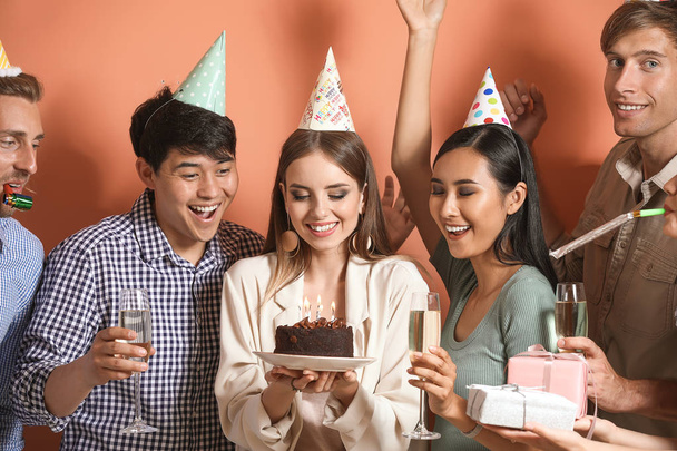 Gruppe von Freunden feiert Geburtstag auf farbigem Hintergrund - Foto, Bild