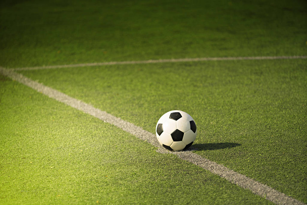 Ποδόσφαιρο ή ποδόσφαιρο σε πράσινο πεδίο με ακτίνα φωτός - Φωτογραφία, εικόνα