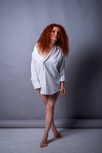 Sexy woman 40 years old in a white shirt on a gray studio background. - Foto, immagini