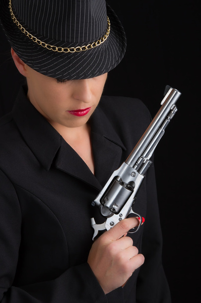 Dangerous woman in black with silver handgun - 写真・画像