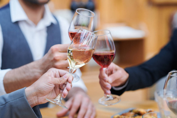 お祝いの乾杯をしながら、3人の人間がバロワスのワイングラスでクリンキング - 写真・画像