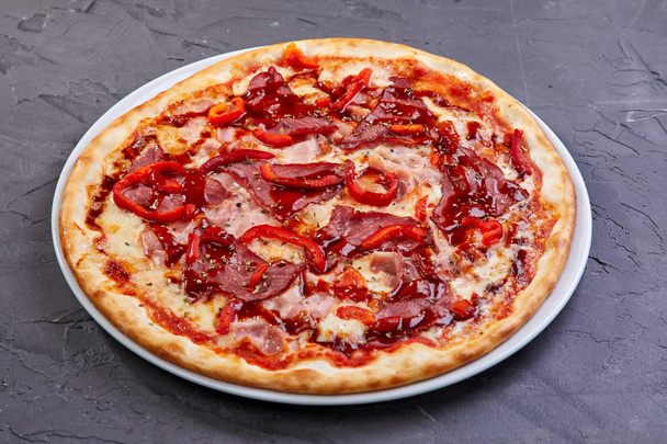 Włoska Pizza z boczkiem i warzywami na białej płycie, zbliżenie  - Zdjęcie, obraz