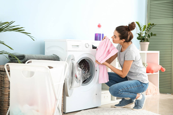 schöne junge Frau beim Wäschewaschen zu Hause - Foto, Bild