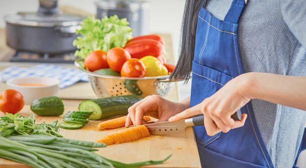 A young woman prepares food in the kitchen. Healthy food - vege - Photo, image