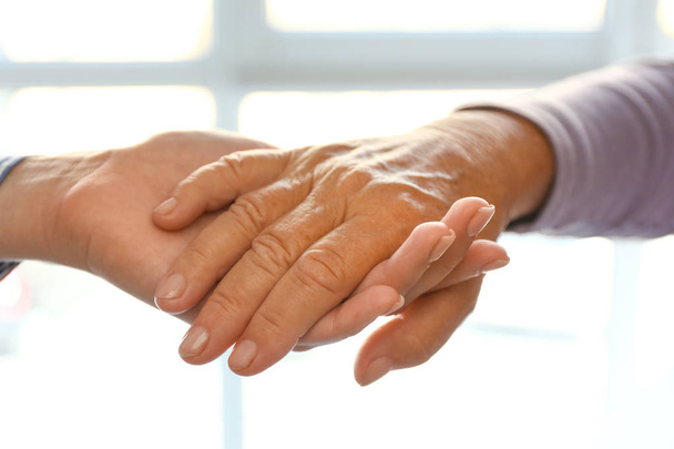 Handen van jonge en bejaarde vrouw, close-up - Foto, afbeelding