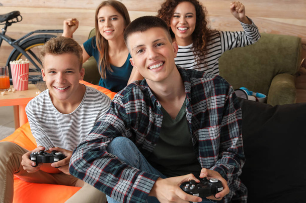 Tieners spelen video game thuis - Foto, afbeelding