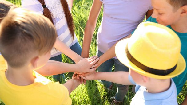 Grupo de niños poniendo las manos juntas al aire libre
 - Foto, Imagen