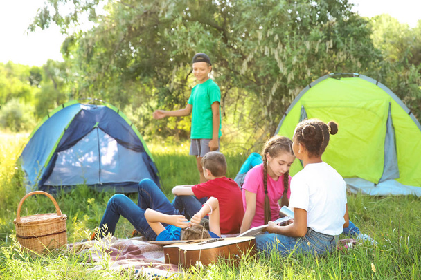 Grupo de crianças descansando no acampamento de verão
 - Foto, Imagem
