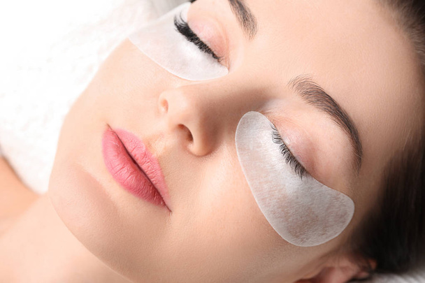 Young woman undergoing eyelash extension procedure in beauty salon, closeup - Foto, immagini