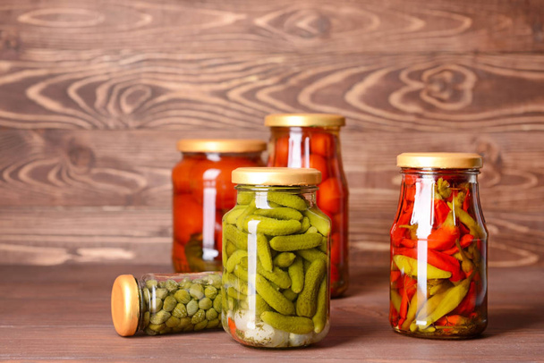 Jars with different canned vegetables on wooden background - Photo, Image