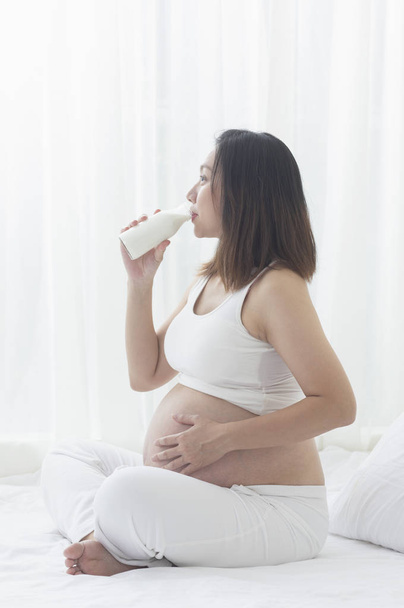 young Asian pregnant woman drinking milk - Foto, Imagen