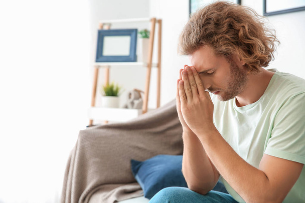 Religieuze jonge man bidden thuis - Foto, afbeelding