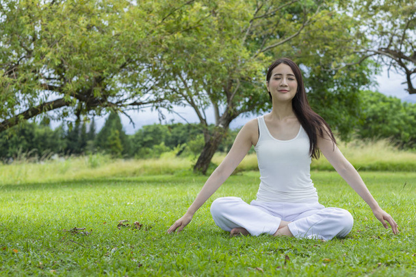 Giovane donna asiatica che fa yoga al parco estivo
 - Foto, immagini