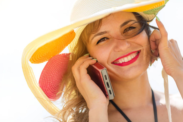 Girl in a wide summer hat with a phone. - Foto, immagini