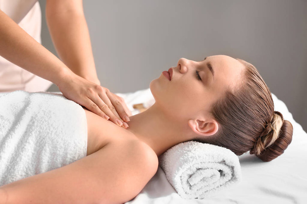 Giovane donna che fa un massaggio nel salone spa - Foto, immagini