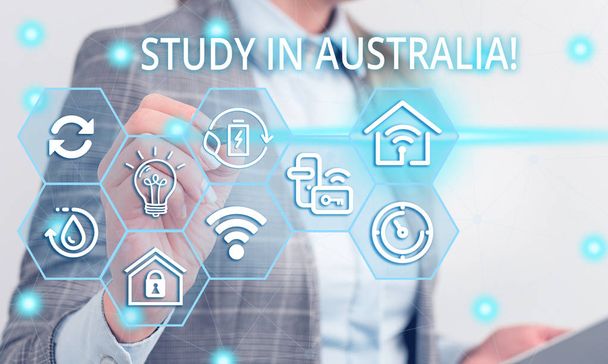 Writing note showing Study In Australia. Business photo showcasing going into foreign country order complete your studies Female human wear formal work suit presenting smart device. - Photo, Image