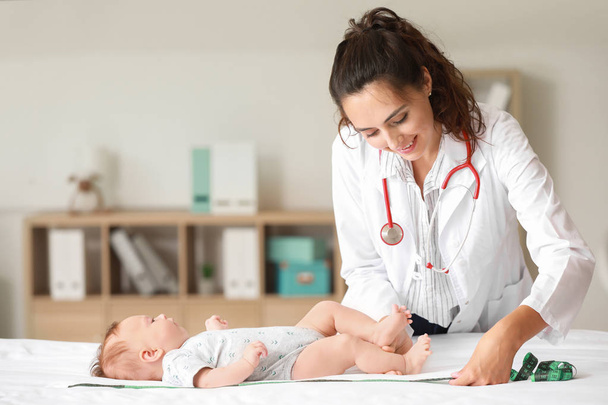 Lastenlääkäri tutkii pientä vauvaa klinikalla
 - Valokuva, kuva