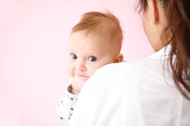 Pediatrician with cute little baby on color background - Photo, Image