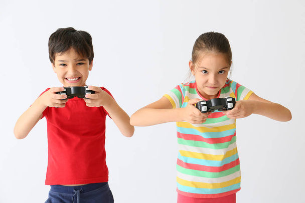 Niños emocionales jugando videojuegos sobre fondo claro
 - Foto, imagen