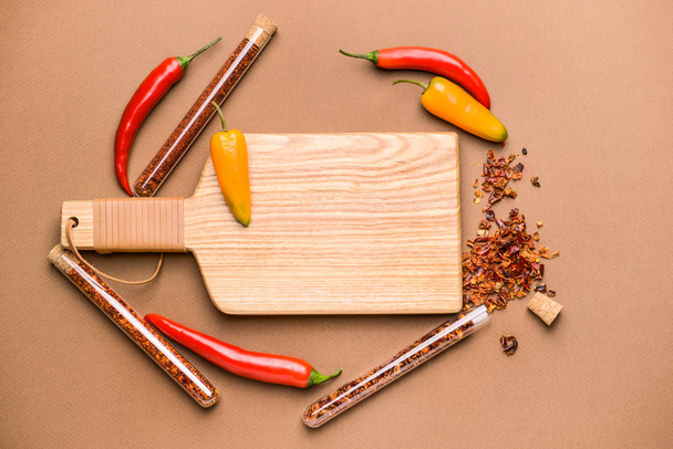 Dry pepper in tubes with wooden board on color background - Zdjęcie, obraz