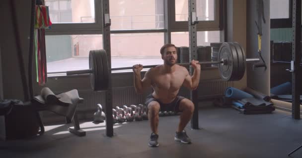 Closeup portrait of adult shirtless attractive caucasian man powerlifting in the gym indoors - Séquence, vidéo