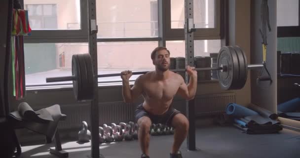 Closeup portrait of adult shirtless muscular caucasian man powerlifting in the gym indoors - Video
