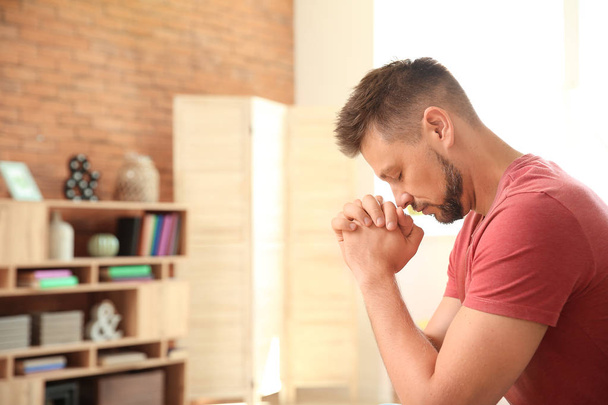 Homem religioso orando em casa
 - Foto, Imagem