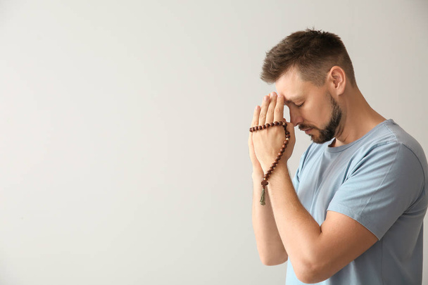 Религиозный человек молится на светлом фоне
 - Фото, изображение