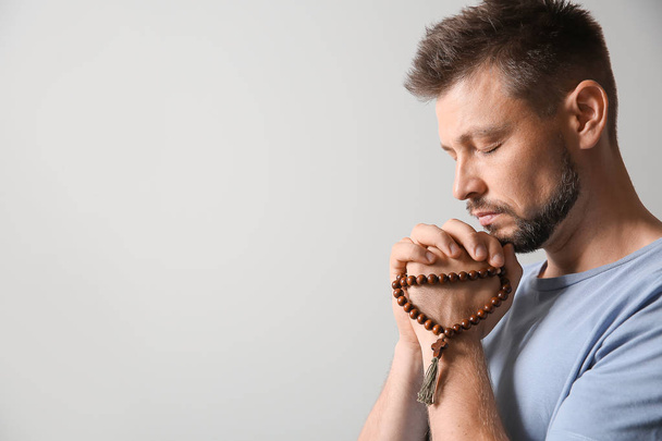 Uomo religioso che prega su sfondo chiaro
 - Foto, immagini